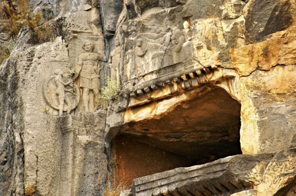 Pictures & images of the ancient Lycian rock cut tomb of a Gladiator whose rock relief sculpture can be seen with his family, Myra, Anatolia, Turkey, Asia