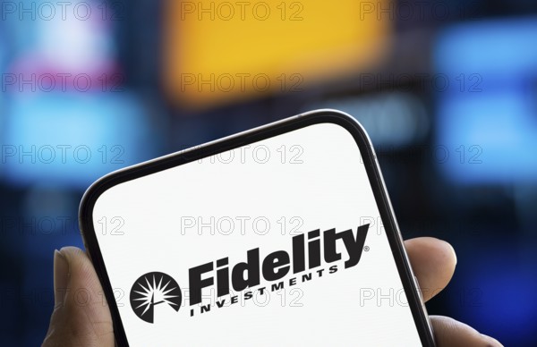 Fidelity investments logo is displayed on smartphone. Fidelity Management & Research is an American multinational financial services corporation