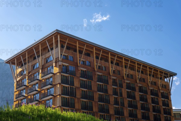 Beautiful Modern Hotel Building in Wood and with Mountain in a Sunny Summer Day in Andermatt, Uri, Switzerland, Europe