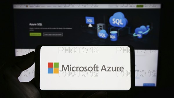 Stuttgart, Germany, 07-11-2023: Person holding cellphone with logo of cloud computing platform Microsoft Azure on screen in front of business webpage. Focus on phone display, Europe