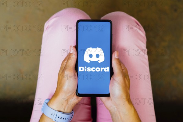 In this photo illustration, the Discord logo is displayed on a smartphone screen