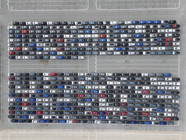 New Cars on Large Parking Lot in Port Ready for Distribution. Harbor Vehicle Storage for Shipping. Automotive Industry. Setubal, Portugal. Aerial Overhead Top-Down Drone Shot.