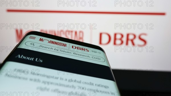 Stuttgart, Germany, 03-06-2022: Mobile phone with webpage of Canadian credit rating company DBRS Morningstar on screen in front of logo. Focus on top-left of phone display, Europe