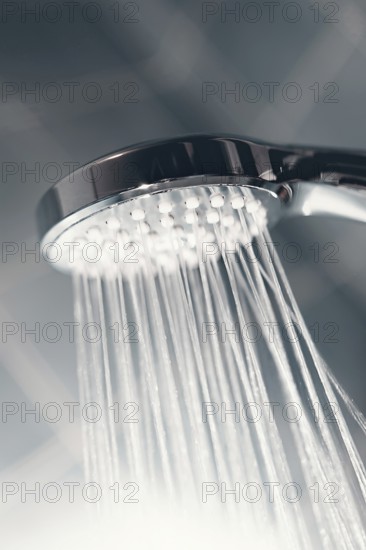 Shower head with flow of water spilling out closeup. Modern shower head splashing water close up