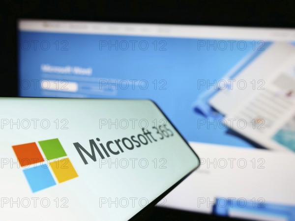 Stuttgart, Germany, 12-19-2022: Cellphone with logo of productivity software Microsoft 365 on screen in front of company website. Focus on center-left of phone display, Europe