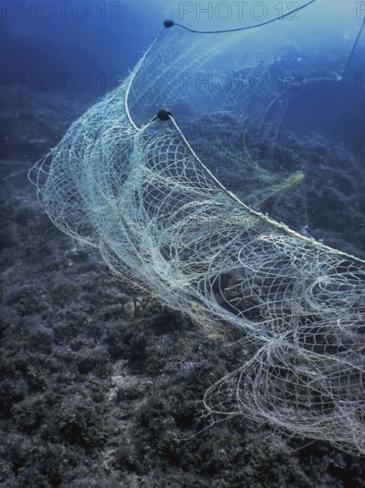 A fishing net underwater fixed on the seabed, deep water