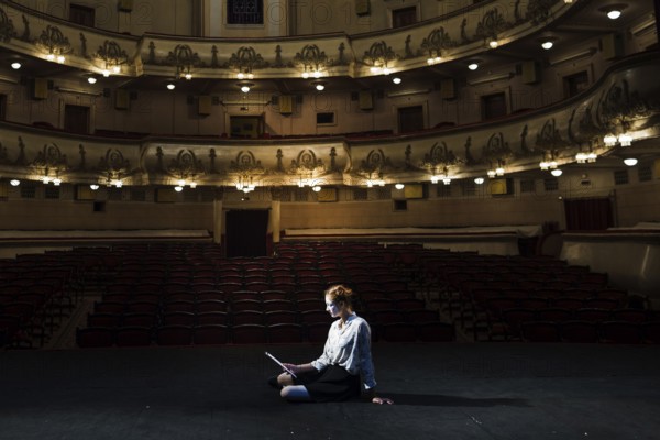 Mime reading manuscript stage empty auditorium. High resolution photo
