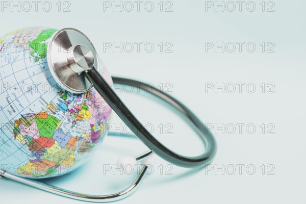 Globe care with stethoscope blue background