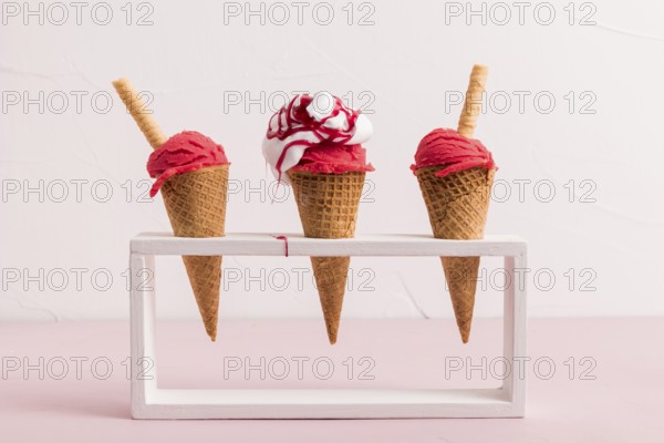 Red ice cream scoop cones with syrup waffle straw stand. High resolution photo