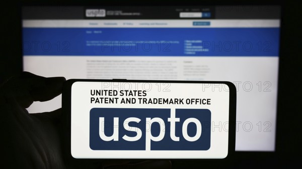 Stuttgart, Germany, 10-29-2023: Person holding smartphone with logo of agency United States Patent and Trademark Office (USPTO) in front of website. Focus on phone display, Europe
