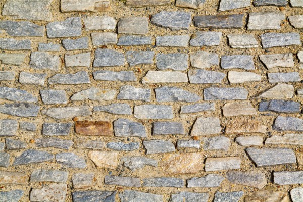 Stone pavement texture. Granite cobblestoned pavement background. Abstract background of old cobblestone pavement close-up