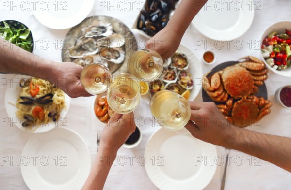 People fine dining seafood and white wine on the table. Top view