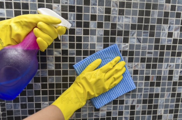 Great home cleaning concept, glove hand wiping tile wall