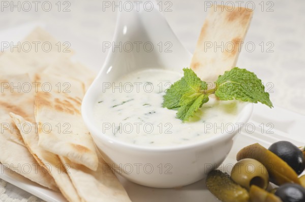Fresh Greek Tzatziki yogurt dip and pita bread and pickels