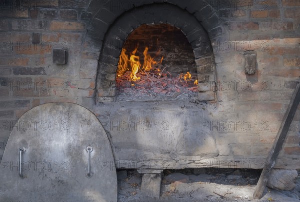 Firing up a traditional bread oven, Münsterland, North Rhine-Westphalia, Germany, Europe