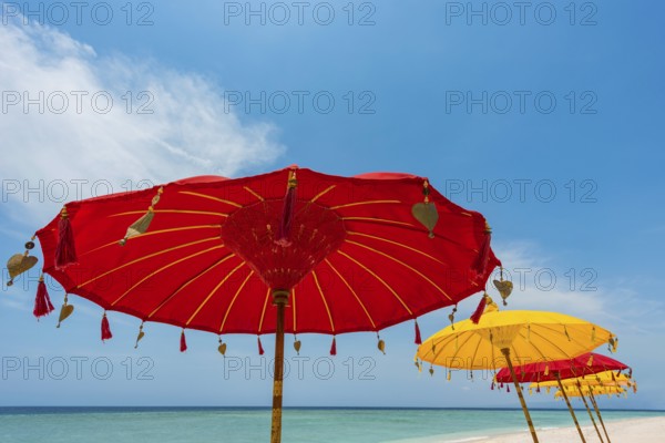 Traditional Balinese temple sunshade as parasol, Hinduism, symbol, beach holiday, protection, sun protection, Balinese, culture, red, yellow, sun, relaxation, relax, blue sky, cliché, holiday cliché, holiday feeling, holiday mood, spa, relax, chill out, shade, shade dispenser, decorated, summer, long-distance travel, exotic, holiday idyll, paradisiacal, water, sea, ocean, coast, travel, holiday, tourism, sea view, Asian, Bali, Indonesia, Asia