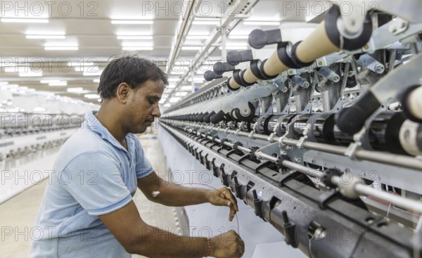 BENIN TEXTILE CORPORATION BENIN. processing cotton in a spinning mill factory near Cotonou in Benin, Glo-Djigbe, 07/03/2024. threading a yarn on a spinning machine