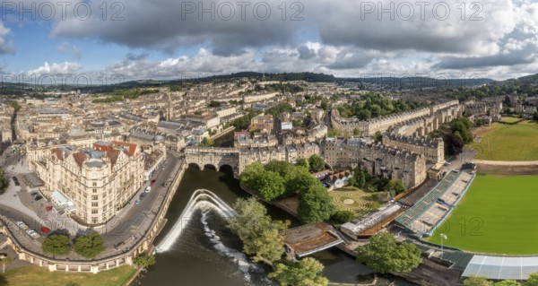 Panorama of a city with river and historic buildings under a cloudy sky, Bath