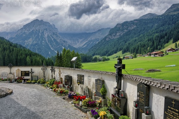 Cemetery of the baroque Roman Catholic parish church of St. Nicholas, cemetery and church under monument protection, Alpine landscape of the Stubai Alps, weather mood, cloudy mood, Obernberg am Brenner, Tyrol, Austria, Europe