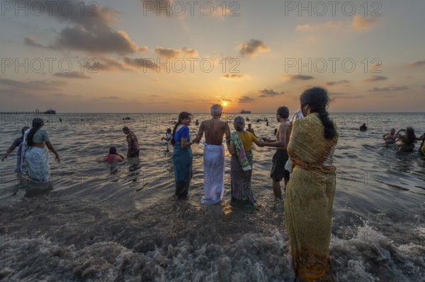 Hindu pilgrims take a holy dip in the sea at sunrise at Ghat Agni Theertham, Rameswaram or Rameshwaram, Pamban Island, Tamil Nadu, India, Asia