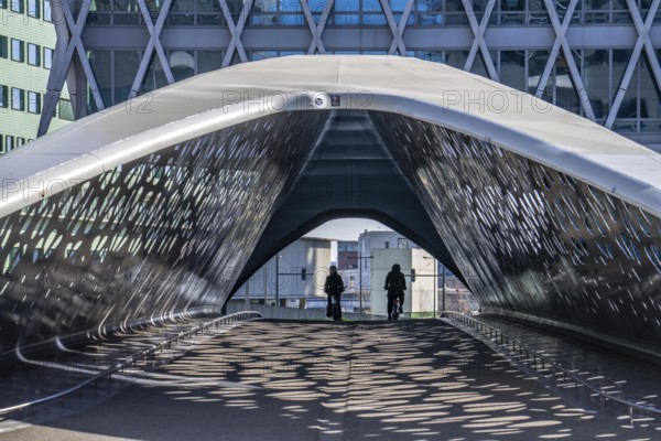 The Parkbruk, cycle and pedestrian bridge in the city centre of Antwerp, crosses a multi-lane city centre road, with tram lines, and thus connects two lively city districts Kop Spoor Noord and Eilandje, light effects by the sun, on the roadway, Belgium, Europe
