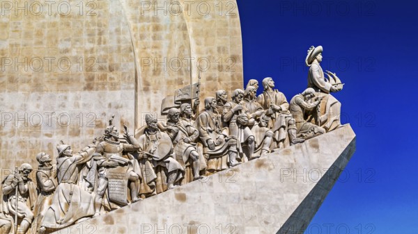 Monumentale Statuengruppe unter klarblauem Himmel, die historische Figuren der portugiesischen Geschichte darstellt, Lisbon