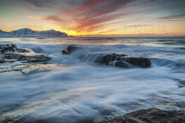 Long exposure, sunset in winter at Skagsanden, rocks washed over by the sea on the beach at Flakstad, Flakstadøy, Lofoten, Nordland, Norway, Europe