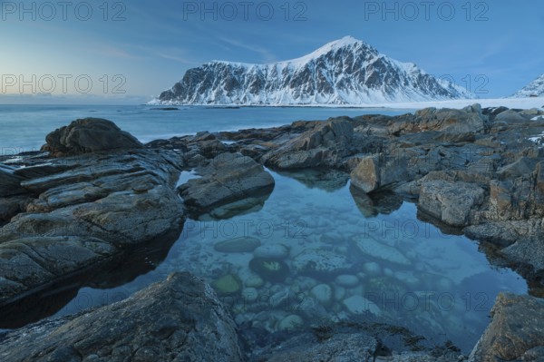 Long exposure, winter at Skagsanden, rocks washed over by the sea on the beach at Flakstad, Flakstadøy, Lofoten, Nordland, Norway, Europe