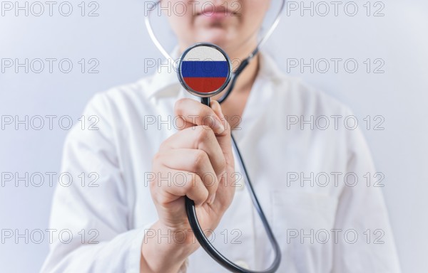 Female doctor holding stethoscope with with Russia flag. Russia health and care concept