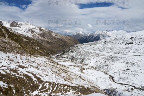 Winterliche Landschaft in den schneebedeckten Bergen von Andorra mit einer Straße und Wolken am Himmel, nördlich von El Pas de la Casa, Pyrénées-Orientales, Encamp, Fürstentum Andorra, Pyrenäen