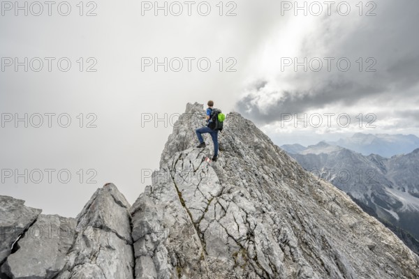 Mountaineer on a narrow rocky ridge, Watzmann crossing to Watzmann Mittelspitze, view of mountain panorama, Berchtesgaden National Park, Berchtesgaden Alps, Bavaria, Germany, Europe
