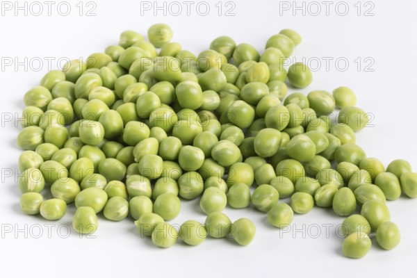 Close-up of a pile of fresh green peas (Pisum sativum) on a white background