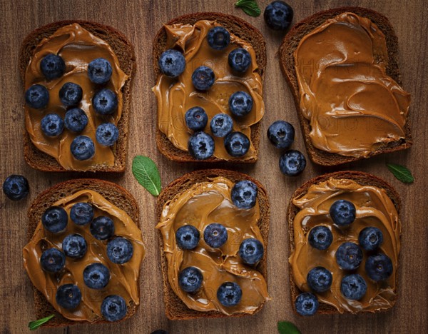 Rye bread with peanut paste and fresh blueberries, top view, no people