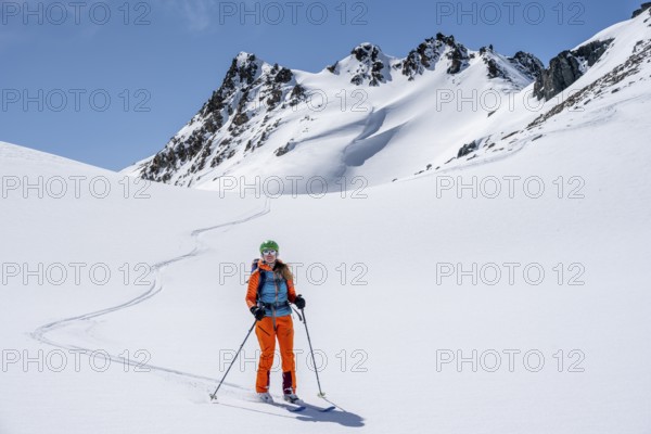 Ski tourer on the descent, minimalist winter landscape, white snow and dark mountains on the Scalettahorn, Graubünden, Switzerland, Europe