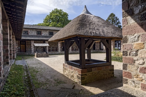 Well house with thatched roof, well in the courtyard of the Principia commandant's office, Saalburg Roman fort, reconstructed cohort fort, museum, archaeological park, Upper Germanic Raetian Limes, border of the Roman Empire, Bad Homburg vor der Höhe, Taunus, Hesse, Germany, Europe