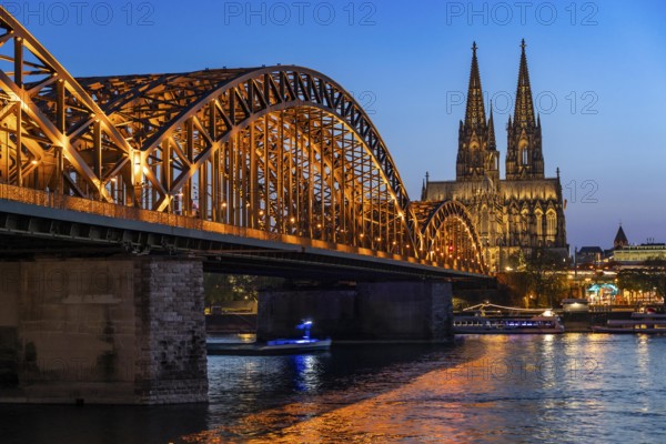 Cologne Cathedral, has been shining in new light since Easter 2025, the old metal halide lamps have been replaced by over 700 modern LED lamps, reducing energy consumption by around four fifths, significantly improving the quality of light and greatly reducing light emissions, 12 KM of new cables were laid for this, Hohenzollern Bridge, railway bridge over the Rhine, North Rhine-Westphalia, Germany, Europe