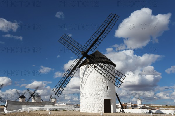A historic white windmill against a blue sky with clouds and sunshine in a vast landscape, windmills, Campo de Criptana, Ciudad Real province, Castilla-La Mancha, Route of Don Quixote, Spain, Europe