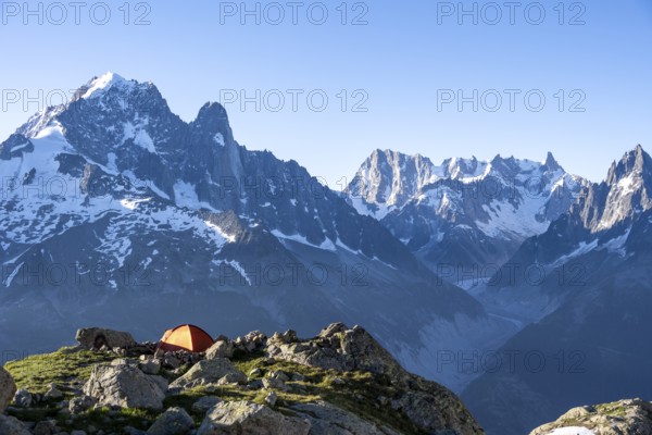 Red tent in front of a mountain panorama, mountain landscape in the morning light, mountain peaks Aiguille Verte and Grandes Jorasses, Mont Blanc massif, Aiguilles Rouges, Chamonix-Mont-Blanc, Haute-Savoie, France, Europe