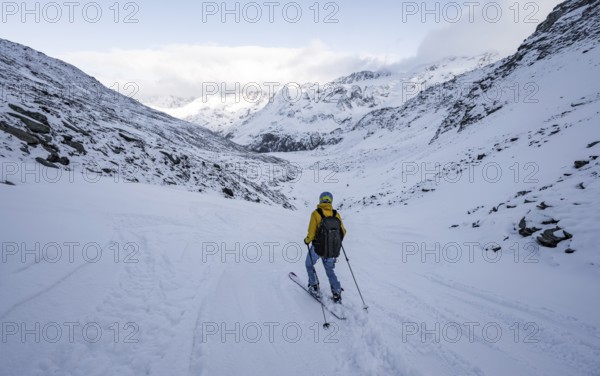Skiers skiing downhill in a snow-covered mountain landscape in the Madritschtal valley, Ortler Alps, Vinschgau Valley, Italy, Europe