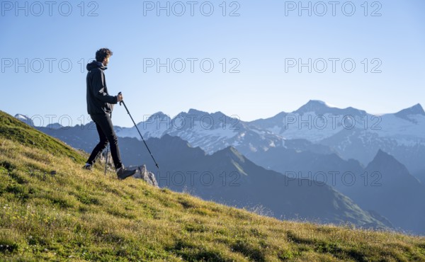 Hiker enjoying the mountain panorama in the morning, Venediger group, behind Dreiherrenkopf, Simonysitze and Großer Geiger, Hohen Tauern, Austria, Europe