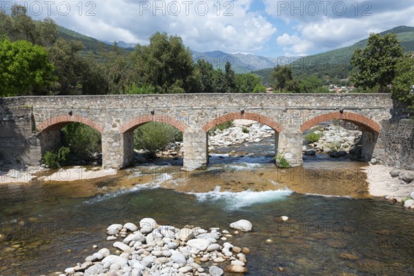 Alte Steinbrücke über einen Fluss in einer gebirgigen Landschaft bei schönem Wetter, Punte Viejo, alte Brücke über den Fluss Garganta de Santa Maria, Candeleda, Ávila, Avila, Kastilien und León, Kastilien und Leon, Spanien