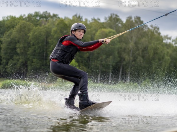 Young man, athletic, fast wakeboarding, water sports, water skiing and wakepark, Stráž pod Ralskem, Czech Republic, Europe