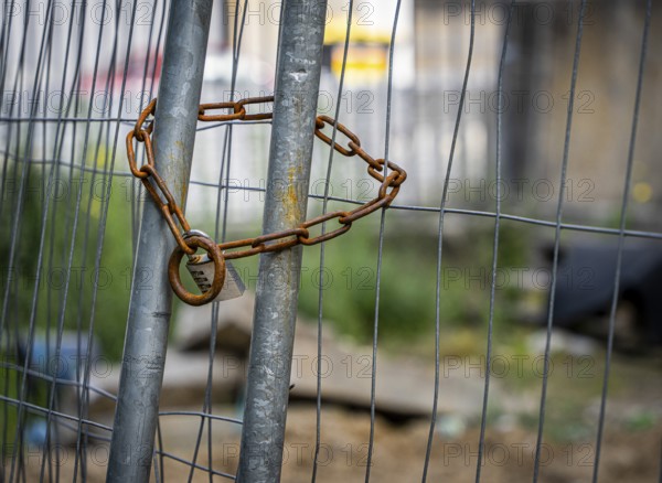 Rusty safety chain on construction fence, Berlin, Germany, Europe