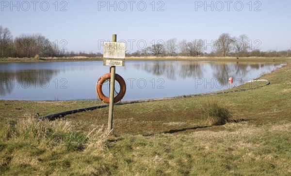 Orange life saving ring by irrigation water reservoir, Sutton, Suffolk, England, United Kingdom, Europe