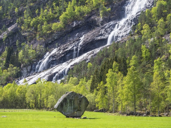 Waterfall Vidfossen, single large rock Oddmundsteinen, south of town Odda at fjord Sørfjord, branch of Hardangerfjord, Hordaland, Norway, Europe