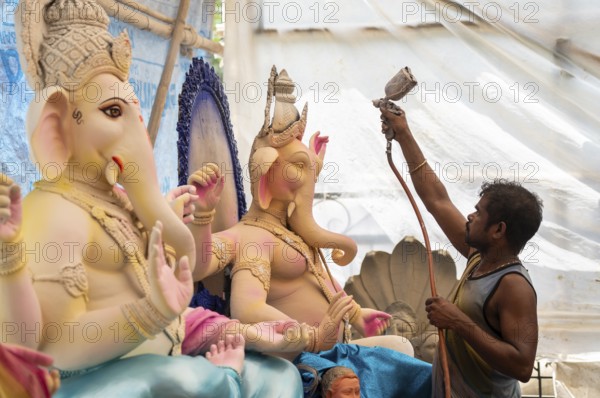 An artisan decorates an idol of the elephant-headed Hindu deity Ganesha at a workshop ahead of the Ganesh Chaturthi festival on September 5, 2024 in Guwahati, Assam, India, Asia