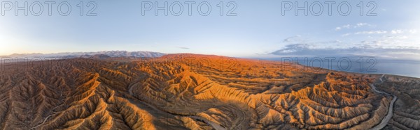 Panorama, landscape of eroded hills, badlands at sunrise, Issyk Kul Lake in the background, aerial view, Canyon of the Forgotten Rivers, Issyk Kul, Kyrgyzstan, Asia