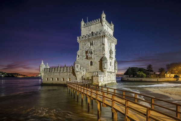 Belem Tower or Tower of St Vincent, famous tourist landmark of Lisboa and tourism attraction, on the bank of the Tagus River (Tejo) after sunset in dusk twilight with dramatic sky. Lisbon, Portugal, Europe