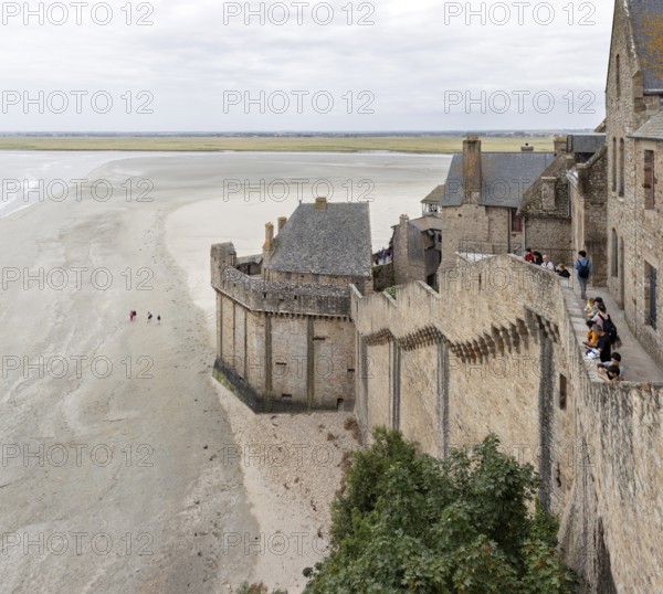 Historic buildings border an extensive sandy beach with views of the sea and the countryside, Le Mont-Saint-Michel