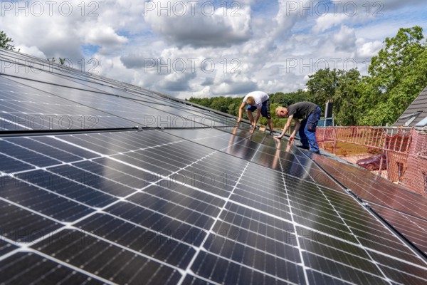 Installation of solar modules on the roof of a barn on a farm, over 210 photovoltaic modules are installed on the roof, North Rhine-Westphalia, Germany, Europe
